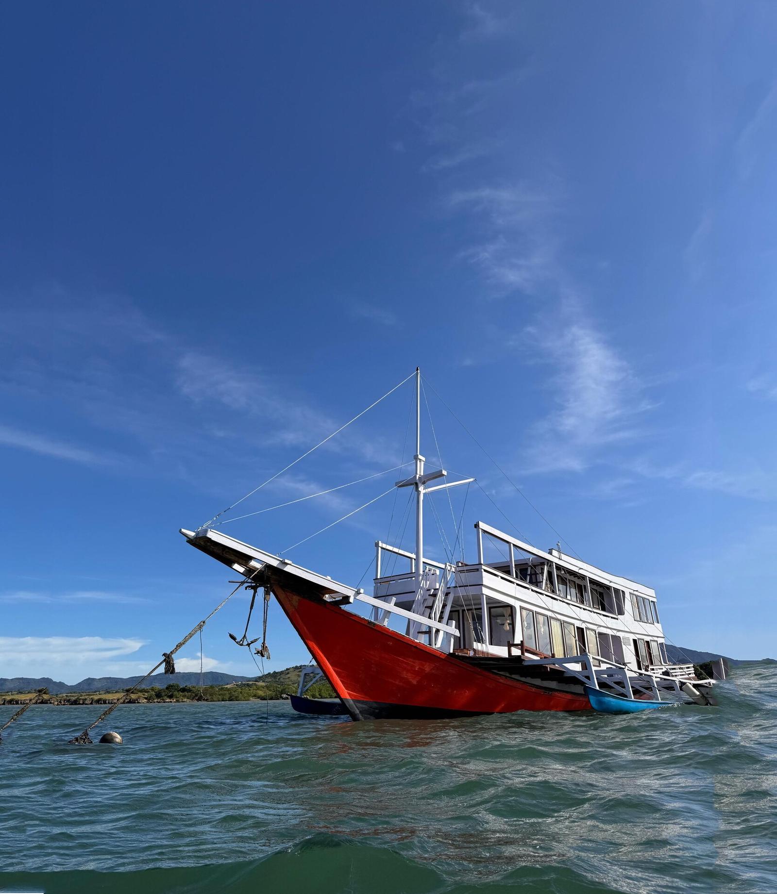 King Cirox 2 at anchor with red hull, white decks and mast
