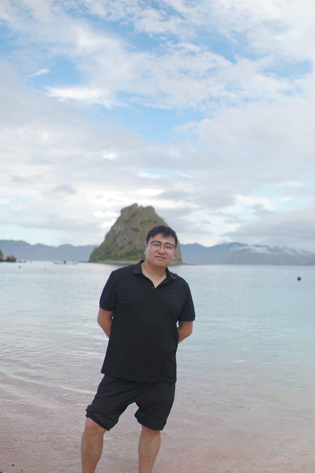 凯洛尔岛 – man standing in shallows, islet behind (Komodo Explorer 行程实拍)