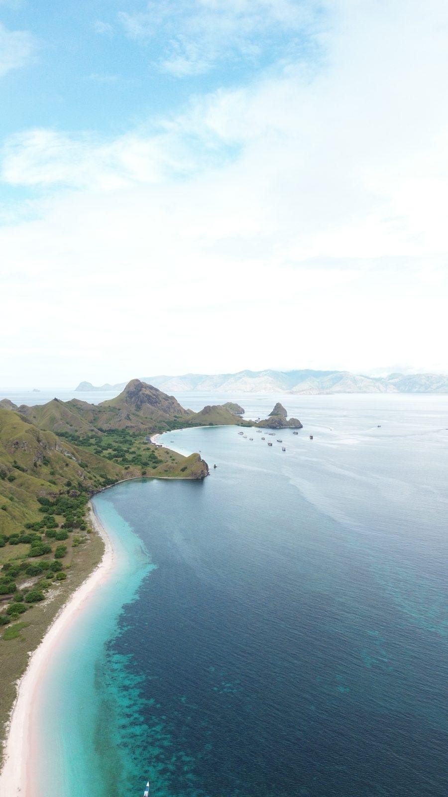 Padar – Aerial coastline, green headland, white beach (Foto real de un viaje de Komodo Explorer)