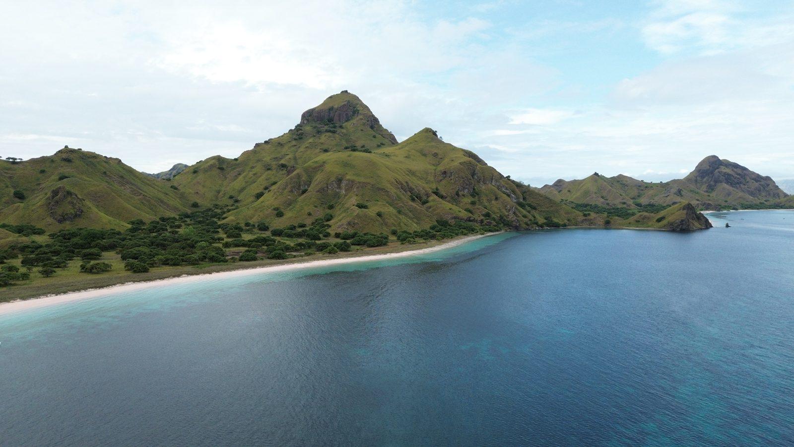 Padar – Aerial jagged green ridge, curved white beach (Foto real de un viaje de Komodo Explorer)