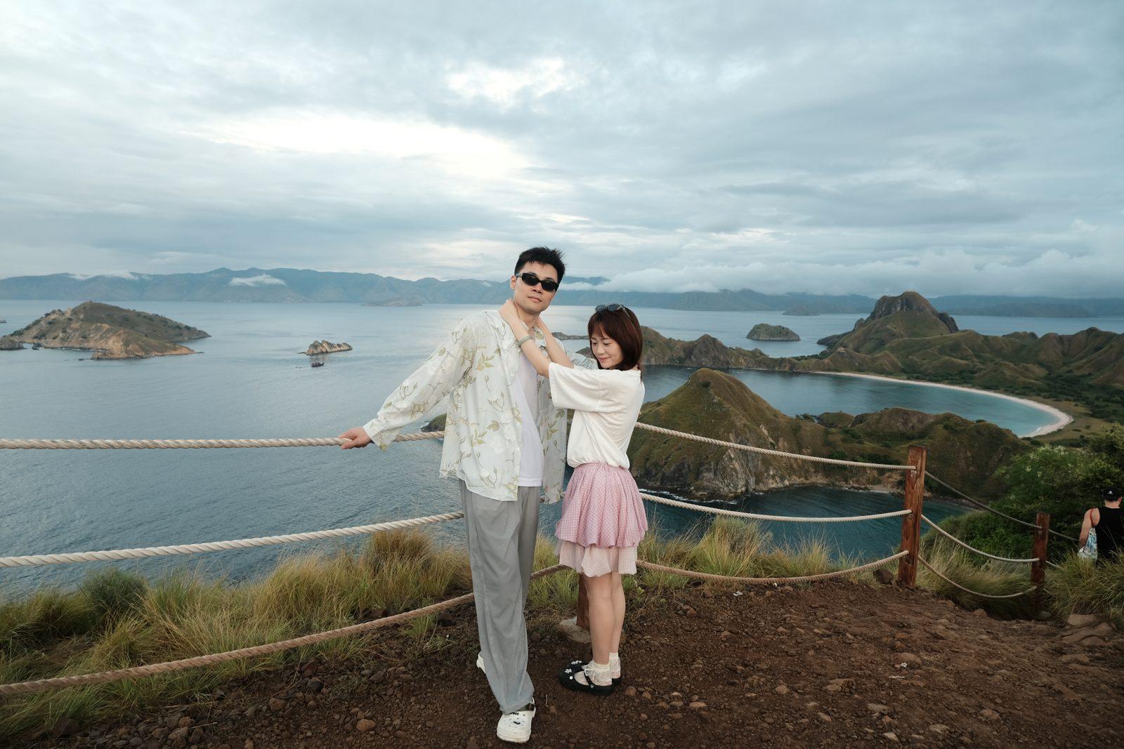 Padar – Couple posing at rail, wide Padar bays (Foto real de un viaje de Komodo Explorer)