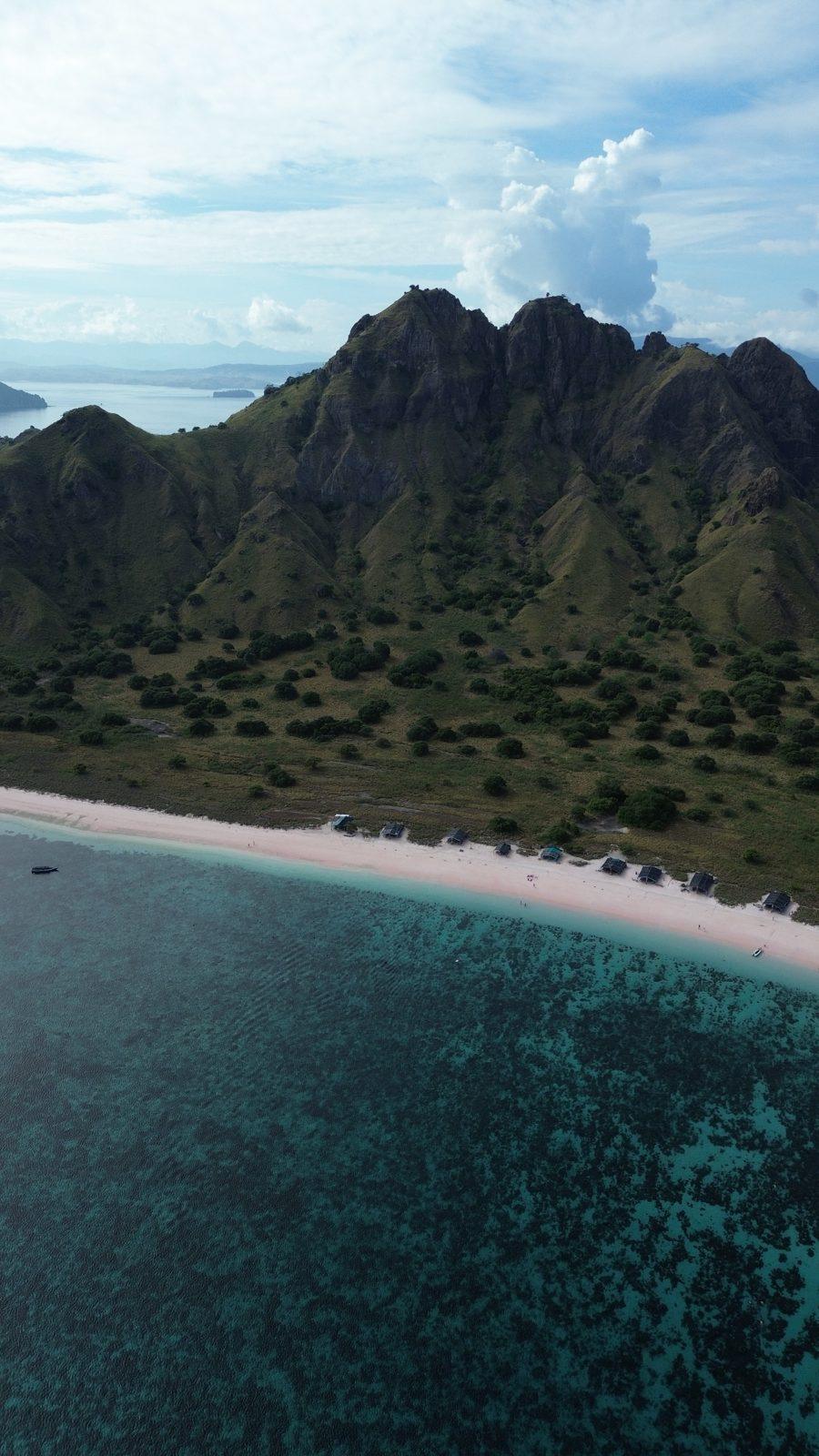 King Cirox 2 Phinisi – Pink Beach, en Komodo: arena rosa pálido, un arrecife junto a la orilla y una parada de tarde