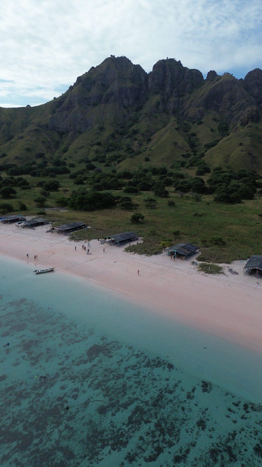 Pink Beach – Aerial pink beach below jagged green ridge (Foto real de un viaje de Komodo Explorer)