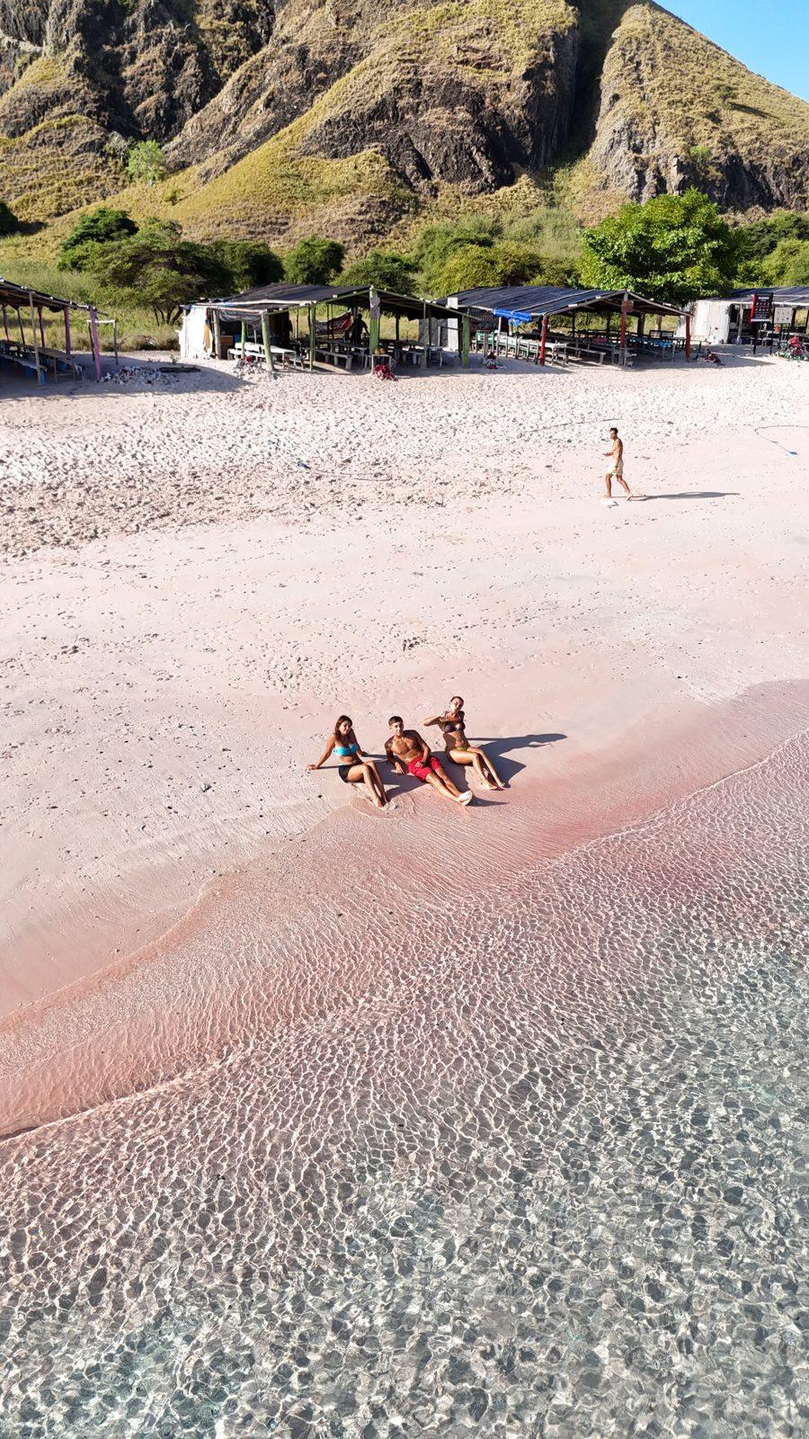 Pink Beach – group lying on pink sand, hill left (Foto real de un viaje de Komodo Explorer)