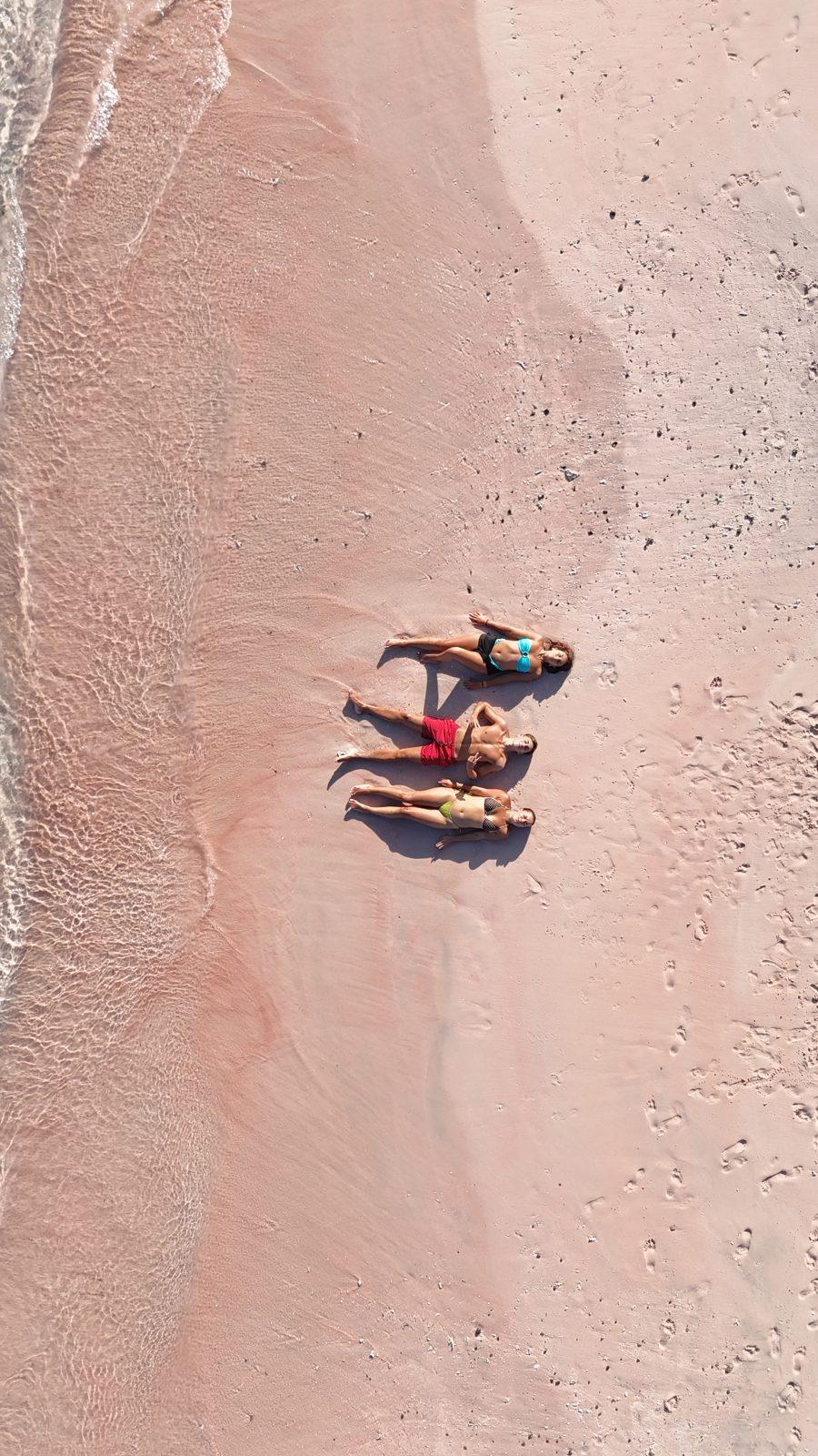 Pink Beach – two people lying on pink sand strip (Foto real de un viaje de Komodo Explorer)